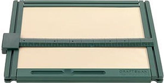 Na zdjęciu widoczna jest prostokątna tablica rysunkowa w kolorze zielonym, przeznaczona dla osób niewidomych i słabowidzących. Składa się z płaskiej powierzchni roboczej oraz ramy z prowadnicami. Przez środek tablicy przebiega pozioma listwa z podziałką, umożliwiająca równe prowadzenie linii i zachowanie proporcji. Po lewej stronie znajduje się element mocujący lub regulujący położenie listwy. Tablica służy do wykonywania rysunków wypukłych lub precyzyjnych szkiców, które można odczytywać dotykiem.