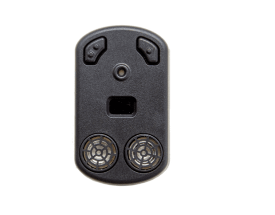 Na zdjęciu widoczne jest niewielkie, czarne urządzenie elektroniczne o podłużnym, zaokrąglonym kształcie, przeznaczone do wspomagania orientacji przestrzennej osób niewidomych. Na jego powierzchni znajdują się dwa przyciski w górnej części, małe oczko sensora pośrodku oraz prostokątne okienko poniżej. W dolnej części umieszczone są dwa okrągłe elementy przypominające kratki głośnika lub czujniki. Urządzenie wykorzystuje technologie sonarowe lub lidarowe do wykrywania przeszkód i informowania użytkownika o otoczeniu.