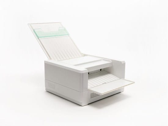 Na zdjęciu widoczna jest drukarka termiczna do tworzenia wypukłych wydruków. Urządzenie ma prostokątną, białą obudowę z otwartą górną pokrywą. W górnej części znajduje się podajnik papieru, a z przodu wysunięta jest tacka odbiorcza z arkuszem. Wewnątrz widoczny jest mechanizm prowadzenia papieru. Drukarka służy do tworzenia grafik i rysunków wypukłych na specjalnym papierze, które można odczytywać dotykiem przez osoby niewidome i słabowidzące.